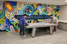 Zoom image: Students playing air hockey in SPPS Cafe and Commons game room