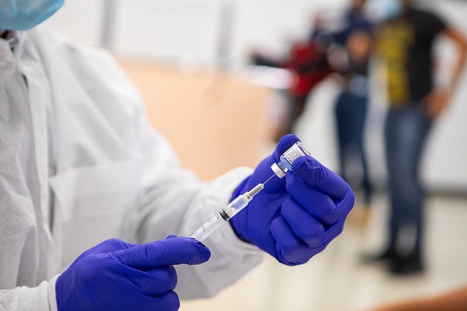 Health care professional preparing immunization. 