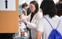 Zoom image: Student leader assisting a PSI student in filling a mock prescription. 