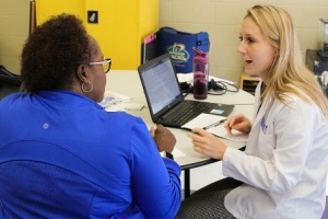 Pharmacy student Renae Gozelski talks with a client at the medication therapy management clinic program at the Gloria Parks Community Center. 
